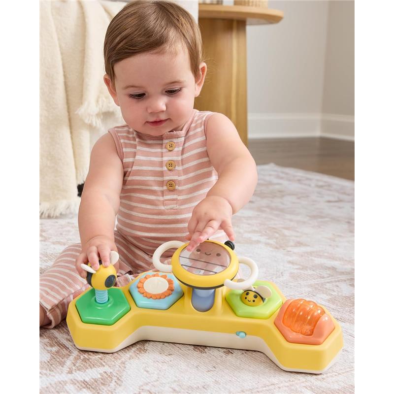 Baby playing with Skip Hop Tummy Time play toy featuring colorful buttons and a mirror, promoting sensory development.