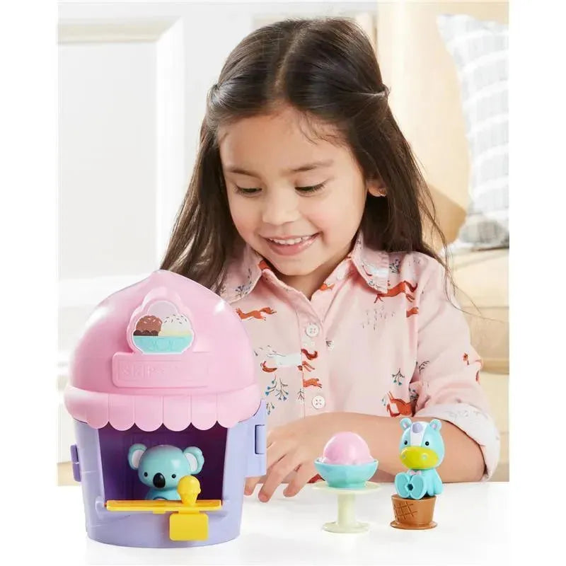 Young girl enjoys playing with the Skip Hop Zoo Ice Cream Shoppe Playset, featuring a koala and a unicorn character.