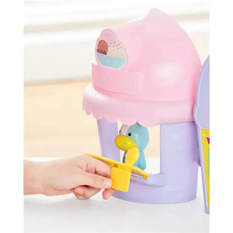 Skip Hop Zoo Ice Cream Shoppe Playset featuring a unicorn, with a child engaging by using a yellow ice cream scoop.