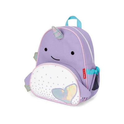 Purple narwhal-shaped backpack with a smiling face, white belly, and iridescent heart detail, designed for kids.