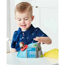 Child playing with Skip Hop Zoo Outdoor Adventure Playset, featuring a monkey sliding down a colorful toy waterfall.