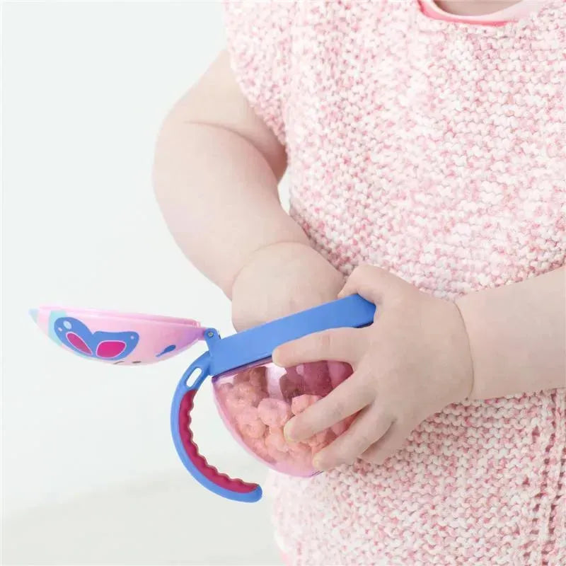 A child holding a Skip Hop Zoo Snack Cup in butterfly design, filled with colorful snacks.