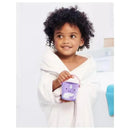 Child in a white bathrobe smiling while holding a purple Skip Hop Zoo Stack & Pour Bucket with a whale design.