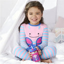 A girl in butterfly-themed pajamas smiles while holding a Skip Hop Zoo stainless steel straw bottle with a butterfly design.