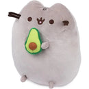 Gray plush Pusheen character holding a green avocado, designed as a cute snackable stuffed animal.