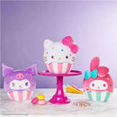 Plush cupcake toys featuring Hello Kitty, with colorful sprinkles, on a pink stand alongside two other character cupcakes.