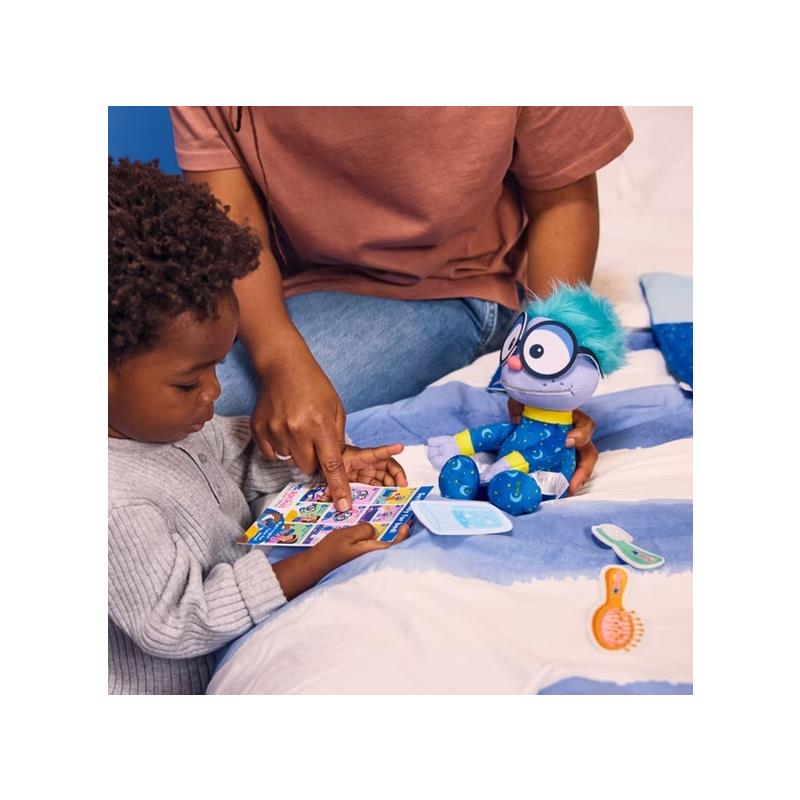 A young child interacts with the Spin Master Ms. Rachel Goodnight Frankie plush toy while an adult guides them, showing a colorful playset.