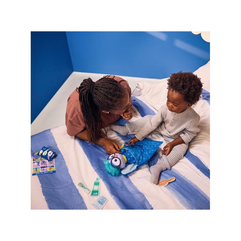 A child and an adult interact on a bed, playing with the Spin Master Ms. Rachel Goodnight Frankie plush toy.
