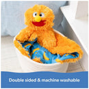 Bright orange plush toy resembling a character, with a blue blanket featuring yellow bananas, in a basket.