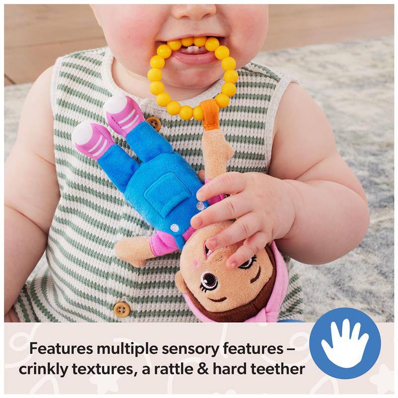 Infant holding the Spin Master Ms. Rachel sensory toy with yellow teether, featuring crinkly textures and a rattle.