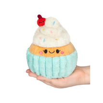 Snacker Madame Cupcake plush toy held in hand, featuring a smiling face, frosting, sprinkles, and a cherry on top.