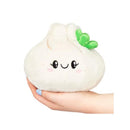 Plush soup dumpling toy with a smiling face, held in a hand, featuring white fabric and a green leafy top.