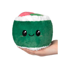 Plush green sushi roll with a smiling face, held in a hand, featuring pink and green toppings.