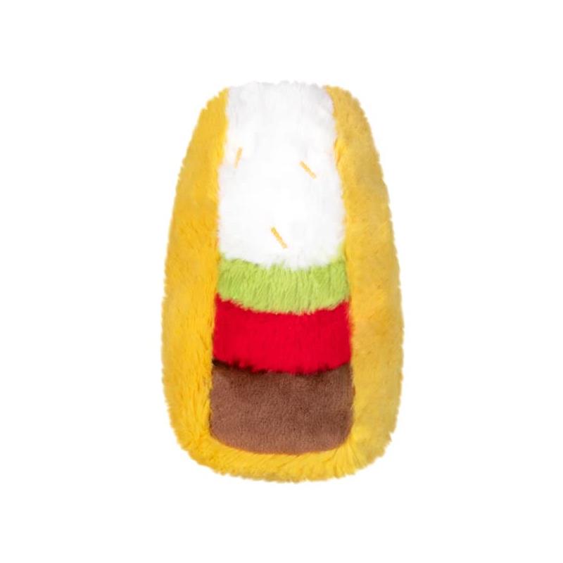 Plush taco-shaped toy with soft layers representing toppings, including white, green, red, and brown colors.