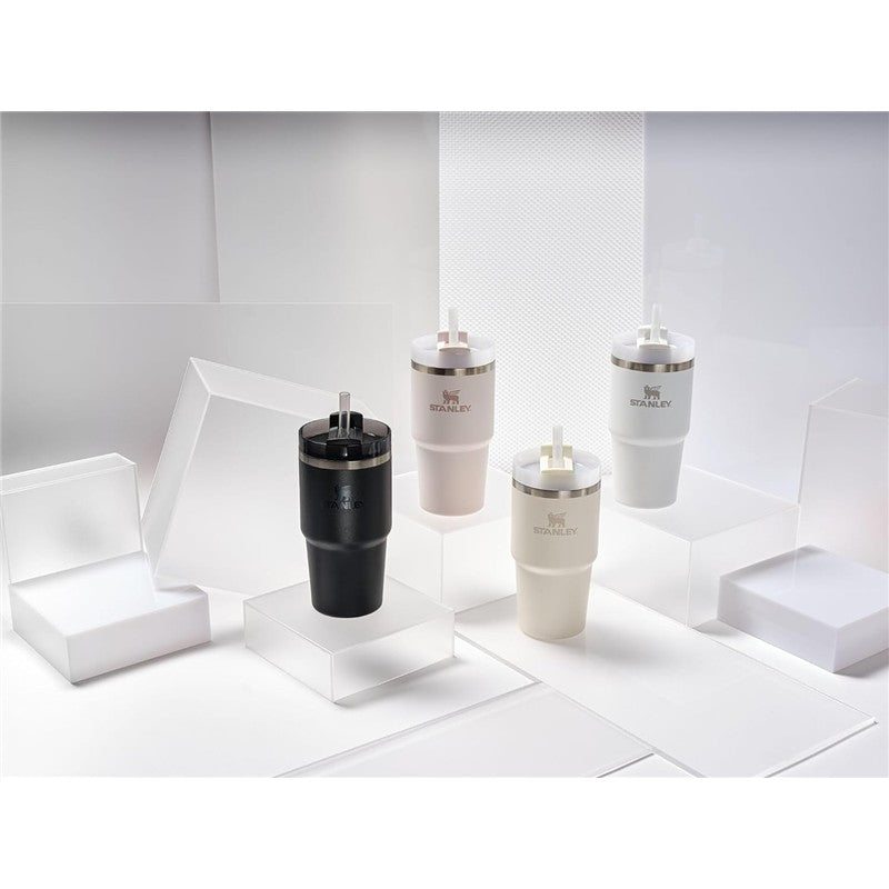 Stanley The Quencher H2.0 FlowState™ Tumblers in black, light pink, and white, displayed on clear platforms.
