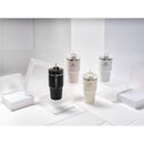 Stanley The Quencher H2.0 FlowState™ Tumblers in black, light pink, and white, displayed on clear platforms.