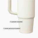Stanley The Quencher H2.0 FlowState™ Tumbler in black, featuring a handle, with labels for cupholder compatibility and double-wall vacuum insulation.