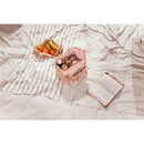 Stanley All-Day Julienne Mini Cooler in cream with snacks, including fruits, on a striped blanket beside an open book.