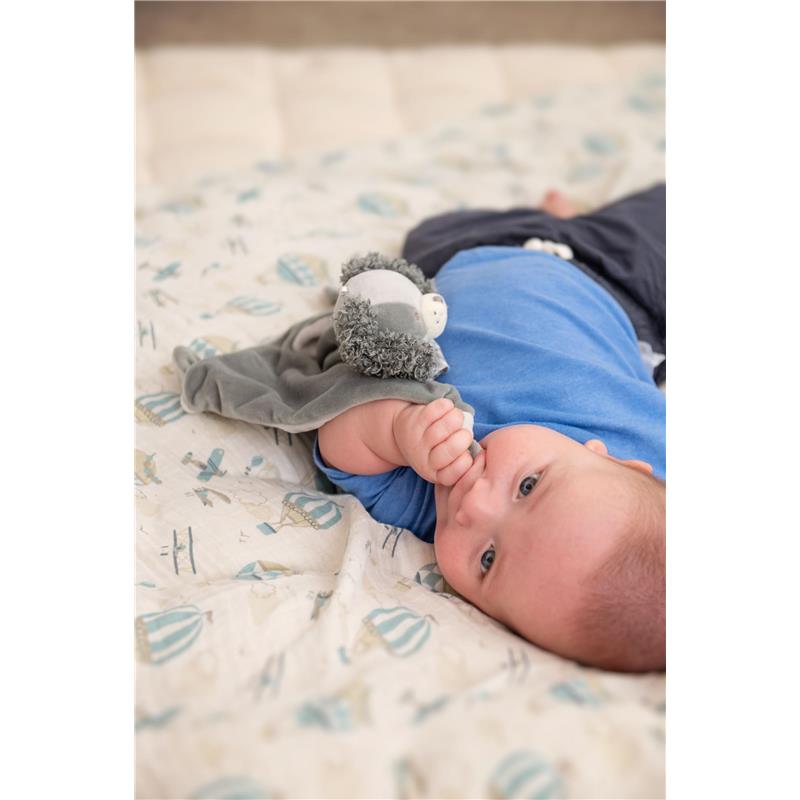 Baby lying on a patterned blanket, holding a gray Stephen Joseph Lovie Panda plush toy.