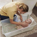 A woman gently bathes a baby in a Stokke Flexi Bath Tub X-Large Bundle, smiling and creating a nurturing environment.