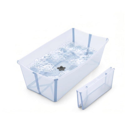 Stokke Flexi Bath Tub X-Large in Ocean Blue, filled with water and bubbles, with a folding insert beside it.