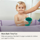Child with a green cup in a Stokke Flexi Bath Tub X-Large, Ocean Blue, enjoying bath time with bubbles.