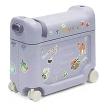 Stokke Jetkids™ Bedbox™ in Arctic Blue, decorated with colorful travel-themed stickers and featuring two wheels for mobility.