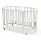 Stokke Sleepi V3 Bed in white, featuring an oval design, slatted sides, and wheels for easy mobility.