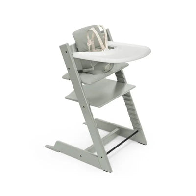 Stokke Tripp Trapp high chair in Glacier Green with a cushion and tray, featuring a secure harness and adjustable footrest.