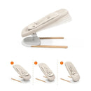 Light sand Stokke Yoga™ Baby Bouncer with three adjustable positions and a modern design, featuring a white base and wooden legs.