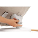 A hand adjusting the height mechanism of the Stokke Yoga™ Baby Bouncer in Light Sand color.