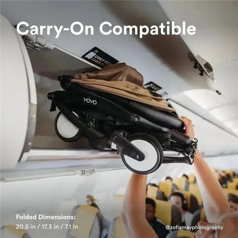 Yoyo stroller in taupe being placed in an airplane overhead compartment, showcasing its carry-on compatibility and folded dimensions.