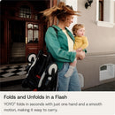 Stokke Yoyo 0+ Newborn Pack in Toffee, held by a woman carrying a child, showcasing easy portability and design.
