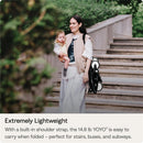 Mother carrying a baby while holding a folded Stokke YOYO3 stroller, showcasing the lightweight and portable design.
