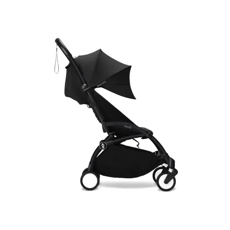 Stokke Yoyo³ 6+ stroller with a black frame, folded with a black canopy and leg rest. Compact design for easy transport.