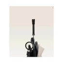Stokke Yoyo³ stroller with a black frame and Bonpoint bundle leg rest, showing a hanging strap and wheel detail.
