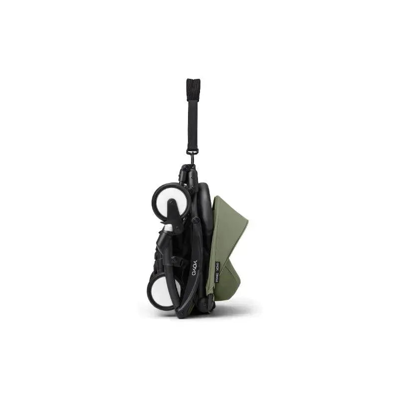 Stokke Yoyo³ Stroller in black and olive, folded, showcasing its compact design and carrying strap.