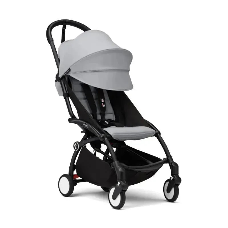 Stokke Yoyo³ stroller in black with a stone-colored seat and canopy, designed for children aged 6 months and up.
