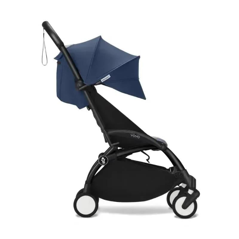 Stokke Yoyo³ stroller in black frame with navy Air France color pack and a bassinet attachment.