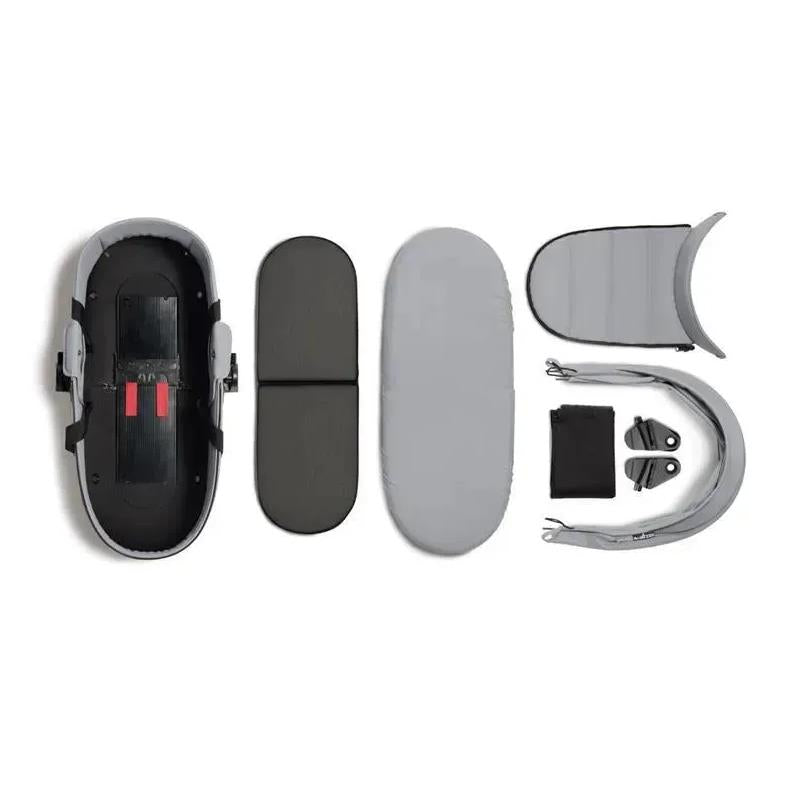 Stokke Yoyo³ stroller bundle components: black frame, stone color pack, stone bassinet, and additional parts arranged neatly.