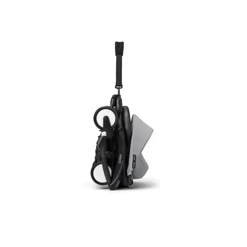Stokke Yoyo³ stroller bundle in a folded position, featuring a black frame and a stone-colored fabric.