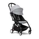 Stokke Yoyo³ stroller bundle with black frame, featuring stone color pack and bassinet, designed for children 6 months and up.
