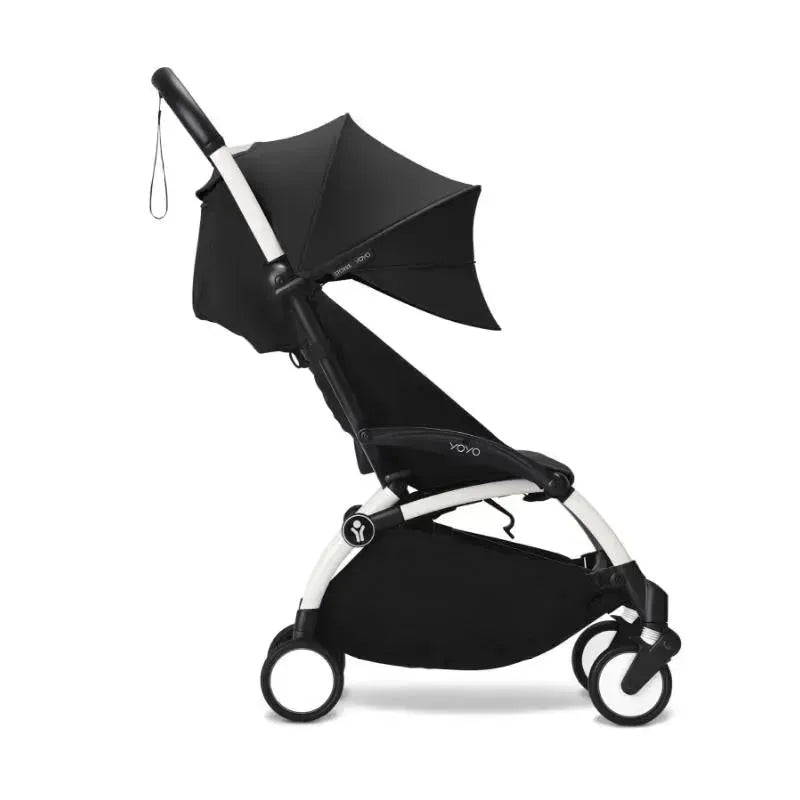 Yoyo³ Stroller in white and black, featuring a black canopy, designed for children 6 months and older.
