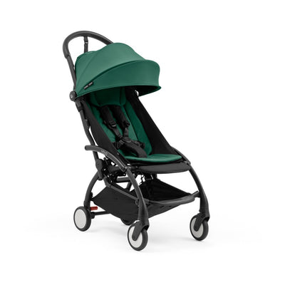 Stokke Yoyo5 compact stroller with a black frame and forest green seat, featuring a canopy and adjustable harness.