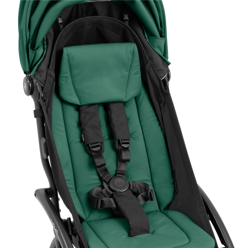Compact Stokke Yoyo5 stroller features a black frame with a forest green seat, equipped with safety harness and padded support.