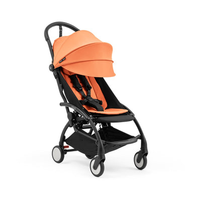 Compact stroller with black frame and orange seat, designed for easy mobility and comfort for children.
