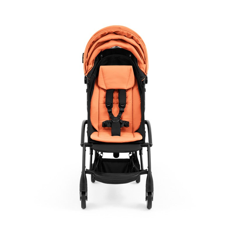 Compact Stokke Yoyo5 stroller with a black frame and peach seat, featuring a harness and storage basket.