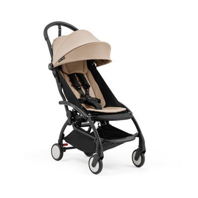 Compact Stokke Yoyo5 stroller with a black frame and taupe seat, featuring adjustable canopy and safety harness.