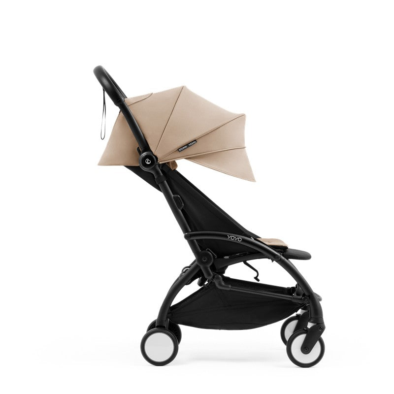 Compact Stokke Yoyo5 stroller featuring a black frame and taupe canopy, designed for easy maneuverability and portability.