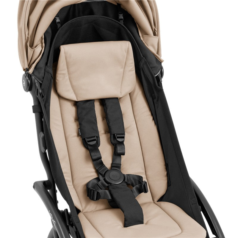 Compact Stokke Yoyo5 stroller featuring a black frame and taupe padded seat with safety harness.